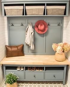 a bench with baskets and hats on it in front of a coat rack filled with shoes