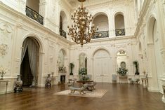 an ornate room with chandelier and wooden floors