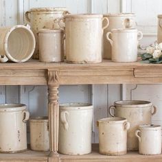 a shelf filled with lots of white dishes and cups