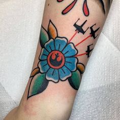 a colorful flower tattoo on the arm