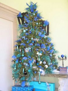 a blue christmas tree with presents under it