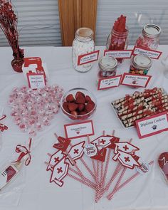 a table topped with lots of candy and candies on top of a white table cloth