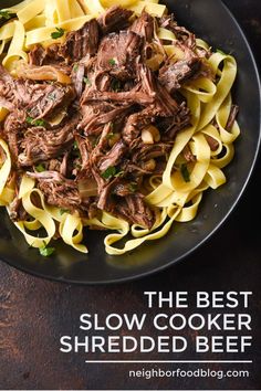 the best slow cooker shredded beef recipe is in a black plate on a wooden table