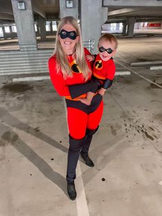 a woman in a red and black costume holding a child