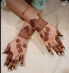 two hands with henna tattoos on them