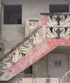 an old building with swans painted on the front and side of it's staircase