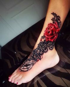 a woman's foot with a red rose and black lace on the top of it