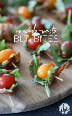 small appetizers with cherry tomatoes, bacon and lettuce on a wooden cutting board