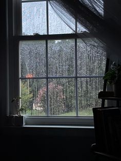 an open window in a dark room with trees outside