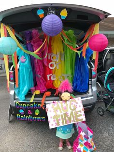 a woman standing in front of a car with balloons and streamers on the back