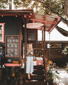 a woman standing in front of a food stand