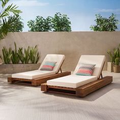 two chaise lounge chairs sitting next to each other on top of a cement floor