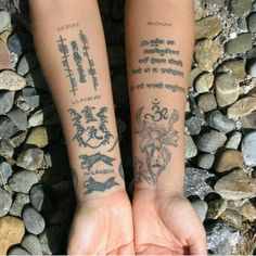 two people holding hands with tattoos on their arms and wrist, both showing different symbols