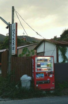 a vending machine sitting next to a wooden fence