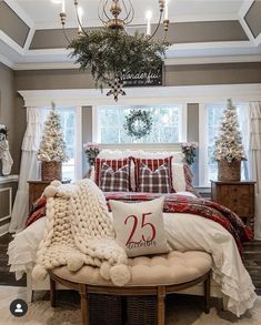 a bedroom decorated for christmas with red and white decor, plaid bedding, pillows, and wreaths