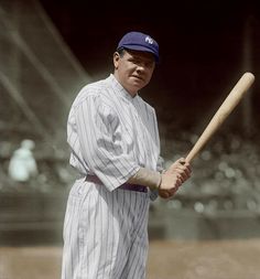 an old photo of a baseball player holding a bat