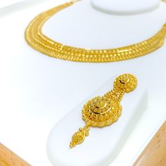 This decadent necklace set is fashioned from 22k yellow gold, weighing 41.8 grams, and adorned with exquisite paisley accents. The set spans 17 inches in length, with 1.75-inch adjustable links for a customized fit, secured by a hook lock. Accompanying the necklace are matching earrings, each measuring 2.2 inches, outfitted with screw backs to ensure both comfort and a secure fit. The intricate paisley motifs add a touch of sophisticated charm, making this set a perfect blend of traditional eleg 22k Yellow Gold Bollywood Jewelry Sets, Heavy 22k Yellow Gold Jewelry Sets, Bollywood Style Hallmarked Gold Necklace, 22k Yellow Gold Bollywood Bridal Necklace, 22k Yellow Gold Chain Necklace For Wedding, Bollywood 22k Yellow Gold Bridal Necklace, Bollywood Style 22k Yellow Gold Bridal Necklace, Yellow Gold Bollywood Bridal Necklace, Gold Bollywood Necklace For Formal Occasions