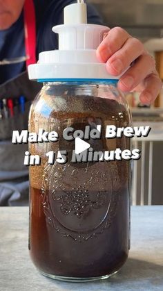 a person is making cold brew in 15 minutes or less with the help of a mason jar