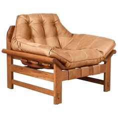 a brown leather chair with wooden frame and foot rest