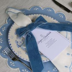 a blue and white place setting with silverware, napkins, and utensils