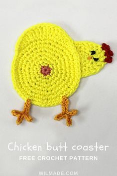 a yellow crocheted chicken sitting on top of a white table next to a sign that says pecking chicken coasters