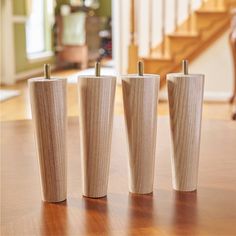 three wooden cups sitting on top of a table next to each other in front of a stair case