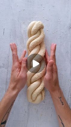 two hands are holding a long hot dog bun