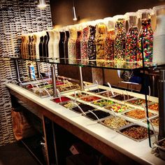 the candy bar is stocked with lots of different kinds of candies and other sweets