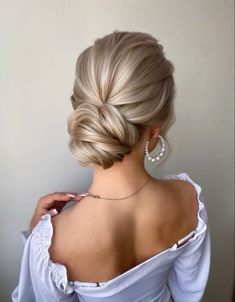 a woman with blonde hair in a low bun