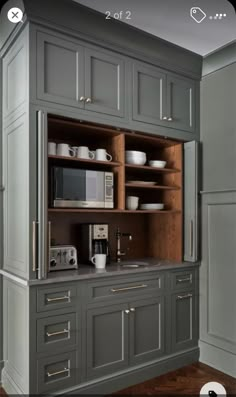 a kitchen with gray cabinets and wooden floors