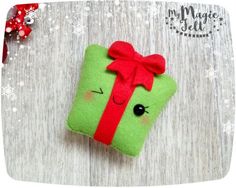 a green pillow with a red bow on it's side and snowflakes in the background