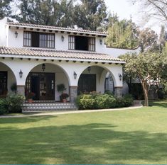 a large white house sitting on top of a lush green field