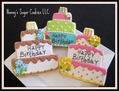 four decorated birthday cookies sitting on top of a white plate