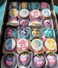 there are many cupcakes in the box with teddy bears and letters on them