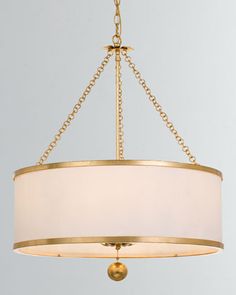 a chandelier with a white shade hanging from it's center point and gold chain around the light fixture