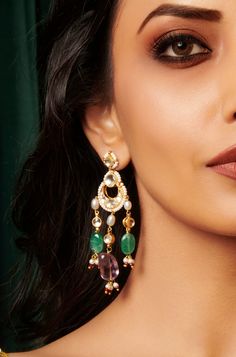 Elevate your style with our elegant earrings, featuring an intricate Kundan encrusted design adorned with seed pearls and delicate dangling kundan units. The earrings are embellished with jade green and amethyst stones, adding a luxurious touch. Perfect for any special occasion, these earrings are a must-have for adding a touch of elegance to your look. Finish: 22KT Gold Plating Material: Silver, Copper Alloy, Natural Stones & Pearls Color: Multicolored Size: One Size Closure Type: Push Back Box