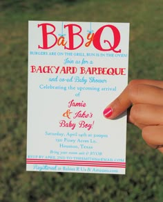 a person holding up a baby q card in their hand