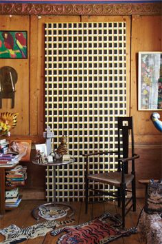 a living room filled with furniture and art on the wall next to a wooden paneled wall