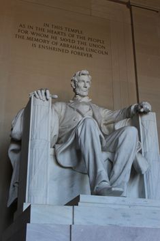 the lincoln memorial is shown in white marble and has a statue of abraham lincoln on it