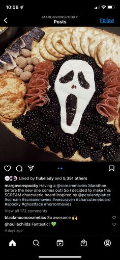 a plate with crackers and blackberries in the shape of a ghost