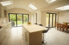 a kitchen with an island, table and chairs next to sliding glass doors that open up onto a patio