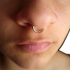 a close up of a person with a nose ring on their nose and the nose piercing is gold