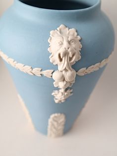 a blue vase with white designs on it