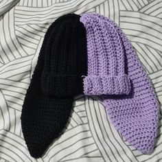 two knitted ties laying on top of a bed