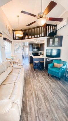 a living room filled with furniture and a ceiling fan