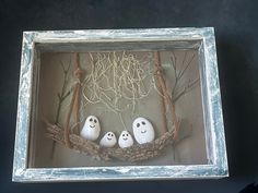 three fake ghost heads in a frame with branches