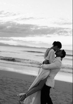 a man and woman kissing on the beach