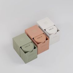 three boxes with different types of soaps in them on a white surface, one is open and the other two are closed