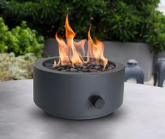 an outdoor fire pit sitting on top of a table