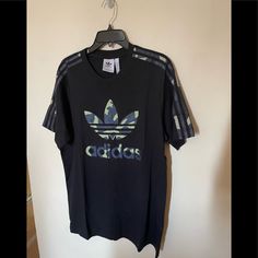 Nwt Adidas Men T-Shirt. It Is Have The Signature Adidas Markers 3 Stripes Trefoil. Regular Fit , Ribbed Crewneck, 100% Cotton Single Jersey. Measurement: Length: 29”( Shoulder To Hem ) Sleeve: 10” No Flaws Or Defects. Comes From A Smoke And Pet-Free Home. Final Price. Green Short Sleeve Top With Three Stripes Branding, Adidas Urban T-shirt For Streetwear, Adidas Green Short Sleeve T-shirt, Adidas Urban T-shirt With Graphic Print, Adidas Green T-shirt For Streetwear, Urban Adidas Tops With Three Stripes, Black Adidas Shirt For Streetwear, Adidas Black Shirt For Streetwear, Casual Green Adidas T-shirt